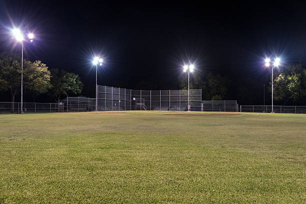 istock Empty baseball field at night with the lights on 491517604