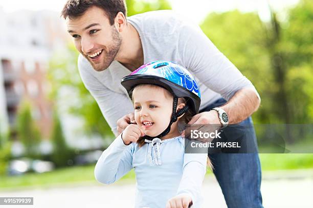 Father Helping Daughter With Bike Helmet Stock Photo - Download Image Now - Child, Helmet, Bicycle