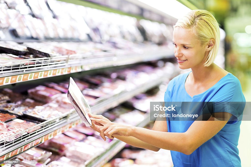 Frau, die ein Produkt Label beim Einkaufen im Supermarkt - Lizenzfrei 30-34 Jahre Stock-Foto