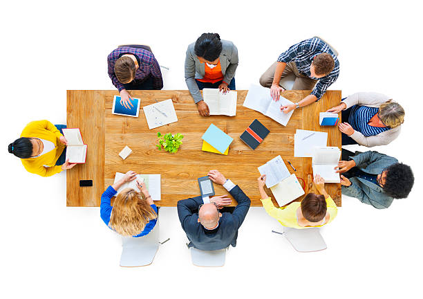 grupo de pessoas de negócios lendo notas sobre uma mesa de reunião - conference table business meeting business directly above - fotografias e filmes do acervo