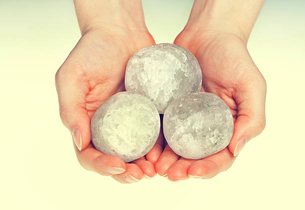 istock Female hands holding round rock salt crystals 491525634