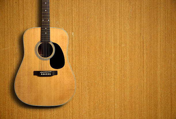 istock Acoustic guitar on wooden background 491528056