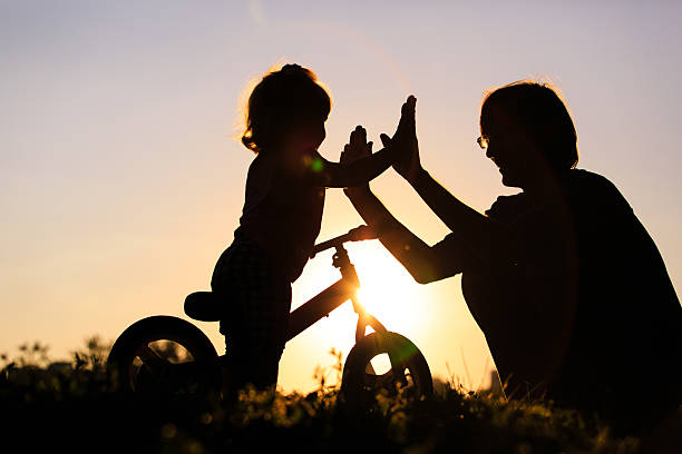istock father and daughter having fun riding bike at sunset 491531966