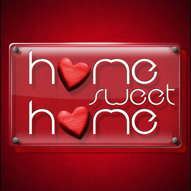 Glass or plexiglass frame with the text Home sweet home on a red velvet background with two red wooden hearts.