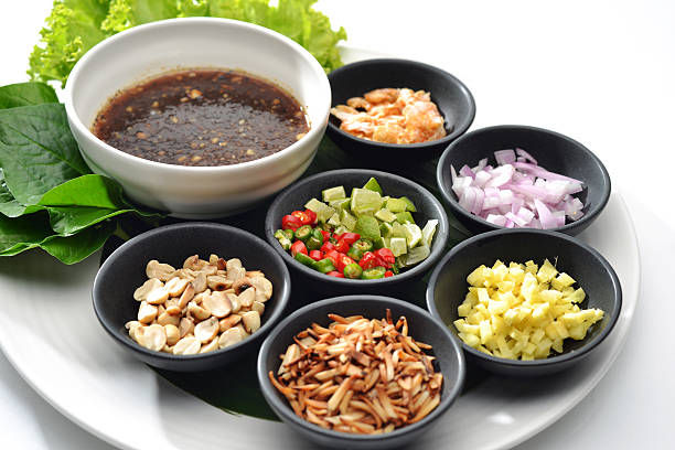 Thai Food wrapped in leaves include many Thai spices are shallots, ginger, chilli, coconut burns, lemon and Ayesha rocket leaves eat with chilli sauce tamarind together