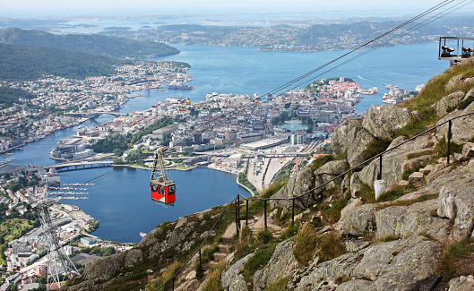 A cable car is seen descending from the station on Table Mountain National Park in Cape Town, South Africa.  It is a trip that almost all tourists make, to view the city from the top of the mountain. Photo shot in the afternoon sunlight on a clear, cloudless day; horizontal format. No people. Copy space.