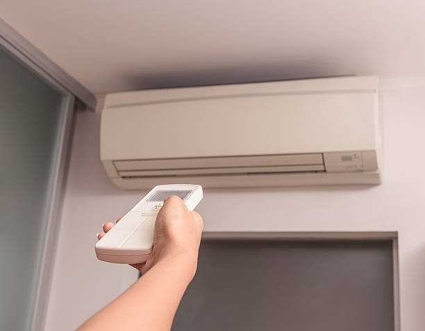 istock Hand With Remote Control Directed On The Air Conditioner 491542328