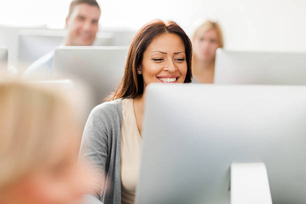 счастливая женщина в компьютерный класс. - computer lab computer adult people стоковые фото и изображения
