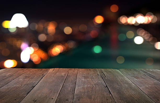 istock Wood table with city lights night blurred background 491545520