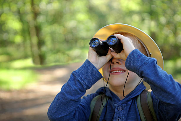 istock Boy in Pith Helmet Looking Up Through Binoculars Outdoors 491546226