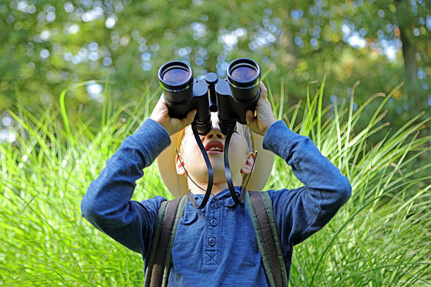 chłopiec w kapelusz safari patrzy w górę przez lornetki na zewnątrz big - little boys discovery binoculars child zdjęcia i obrazy z banku zdjęć