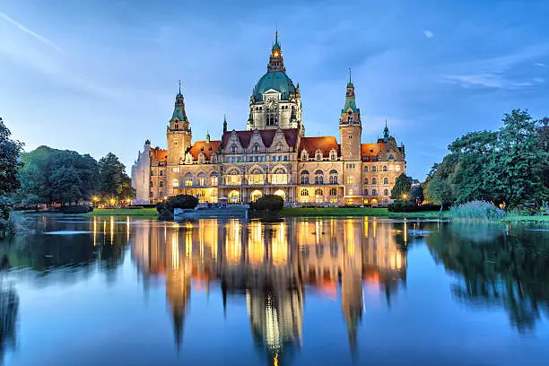 New City Hall of Hannover reflecting in water in the evening, Lower Saxony, Germany