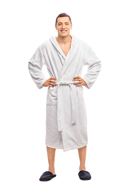 Cheerful young man in a white bathrobe Full length portrait of a cheerful young man in a white bathrobe isolated on white background bathrobe stock pictures, royalty-free photos & images