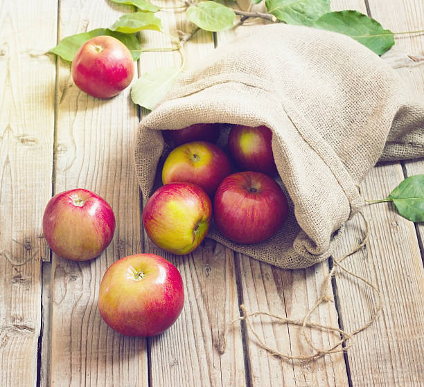 istock Ripe red apples in a bag on wooden background 491560208