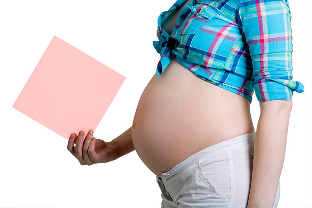 istock Pregnant beautiful young woman with blank post-it note 491561854