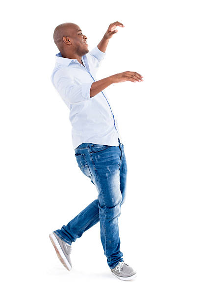 Casual man falling Casual full length man falling on his back but looking happy - isolated over white background falling behind stock pictures, royalty-free photos & images