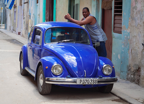 Havana, Cuba - Avgust 2, 2015: Driver near his car Volkswagen Beetle on the street in old Havana.