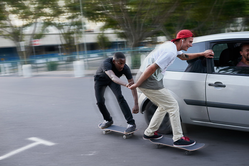 Shot of two skaters holding on to a moving carhttp://195.154.178.81/DATA/i_collage/pu/shoots/805697.jpg