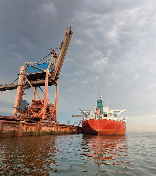 причалить грузовой корабль в гавань на рассвете - harbor editorial industrial ship container ship стоковые фото и изображения