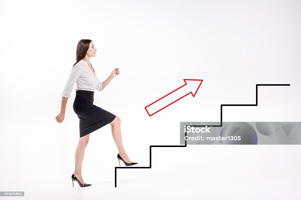 Young businesswoman walking up on stairs Young businesswoman walking up on  steps of the career ladder Climbing Stock Photo