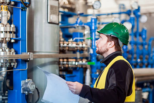 istock Manual worker analysing machinery while holding paper 491575212