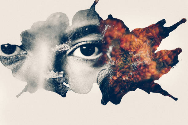 Beautiful closeup of a woman's eyes in monochrome looking at the camera alongside muted natural flower shapes in a graphic splatter effect on a white background