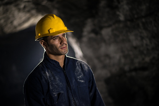Portrait of a Latin American man working at a mine wearing a helmet