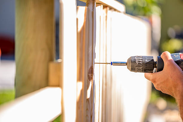 hombre destinando mayores de una valla de madera al aire libre - fence fotografías e imágenes de stock