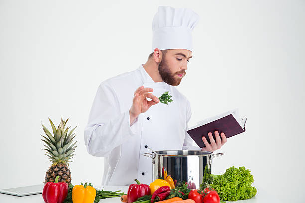 istock Male chef cook reading recipe book while preparing food 491581790