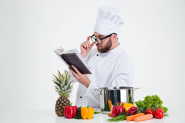 Chef cook in glasses reading recipe book