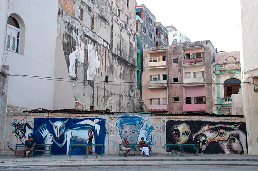 Havana, Cuba - August 10,0 2015:Graffiti and architecture in Old Havana street. People sit on a bench and wait for the bus. 
