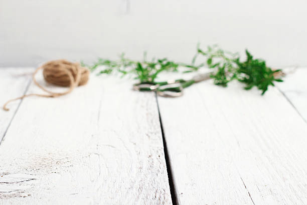 Still life, food and drink, health concept. Mix of fresh herbs on a wooden table, scissors and rope. Selective focus on a copy space white background