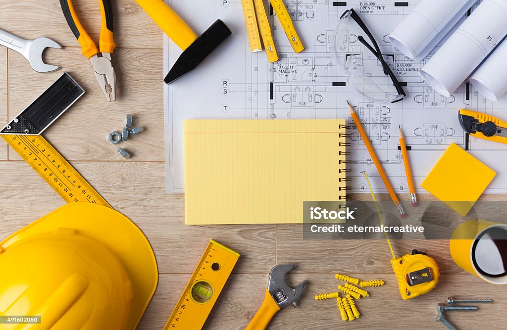 Blueprints and Construction tools Blueprints and Construction tools on wooden background Table Stock Photo