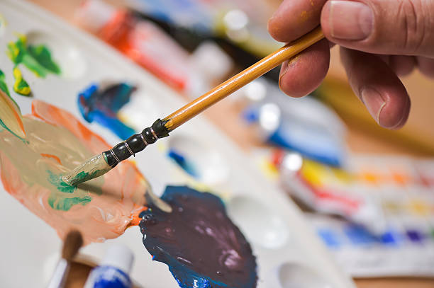 istock Artist's hand applying paint gouache on the drawing sheet 491602300