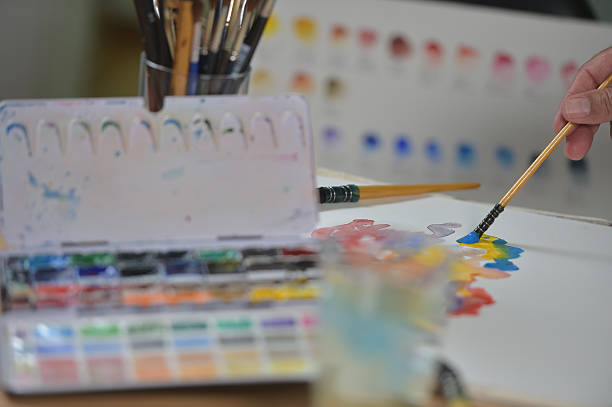 istock Artist's hand applying paint gouache on the drawing sheet 491603190