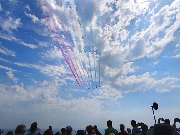 Image of Red Arrows flight display at Bournemouth Air Festival Bournemouth, Dorest, England, UK - August, 22 2015: Photo showing the Red Arrows flight display flying past the delighted crowds on the top of Boscombe's cliff, during the ever-popular Bournemouth Air Festival. stunt airplane airshow air vehicle stock pictures, royalty-free photos & images