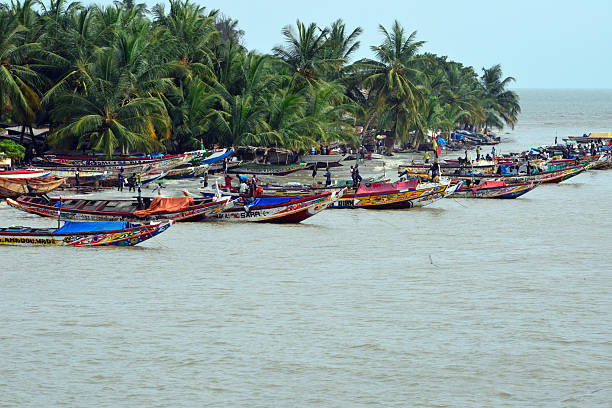 Fishing boats, Banjul island, The Gambia Banjul, The Gambia - August 31, 2015: fishermen preparing traditional wooden fishing boats for a day's work in the Atlantic Ocean and the River Gambia estuary banjul stock pictures, royalty-free photos & images