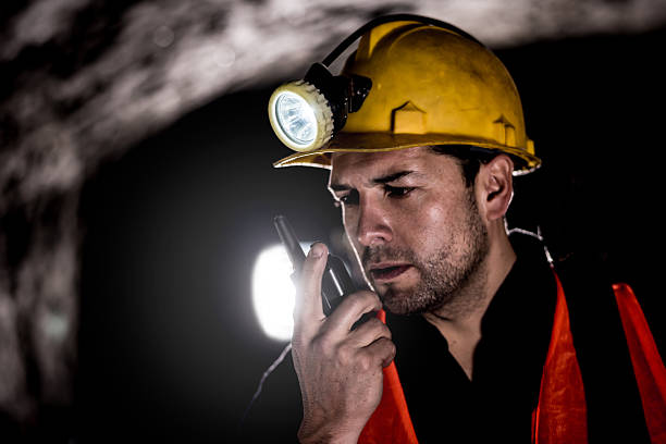 Miner talking on a walkie-talkie Portrait of a miner working at the mine and talking on a walkie-talkie miner stock pictures, royalty-free photos & images