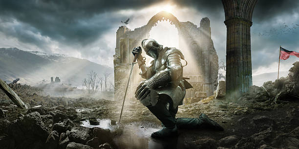 Medieval Knight Kneeling With Sword In Front of Building Ruin A Medieval knight wearing full suit of armour, boots and chainmail, kneeling as if in defeat or contemplation in preparation for battle. He rests on his sword in a puddle amongst rocks and rubble in front of a building ruin under a dramatic stormy evening sky with rays of sunlight. kneeling stock pictures, royalty-free photos & images