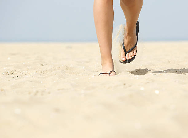 ウォーキング大胆にビーチでのサンダル - flip flop human foot sand women ストックフォトと画像