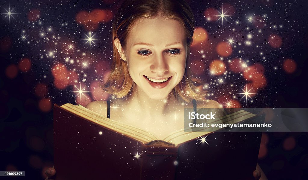 Niña leyendo libro de magia - Foto de stock de Libro libre de derechos