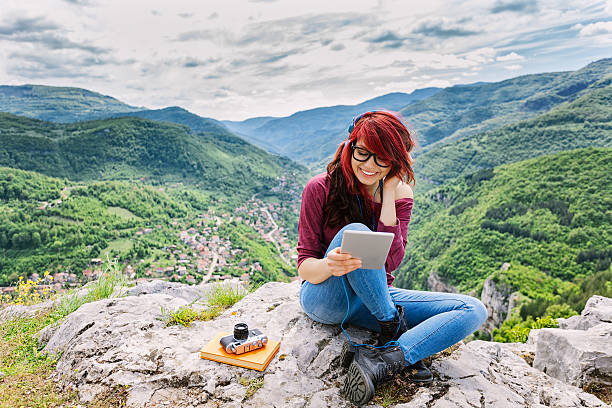 kobieta z słuchawki i tablet pc na góry - high peaks audio zdjęcia i obrazy z banku zdjęć