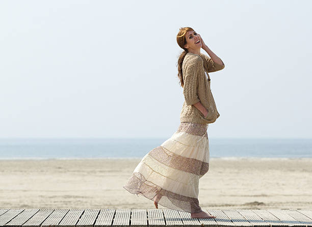 istock Smiling woman walking at the beach 491612663