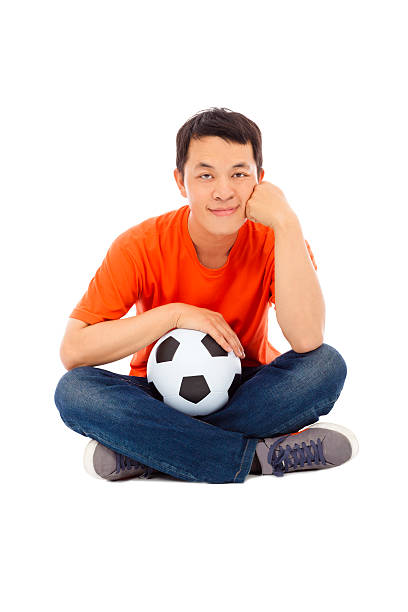 istock young man sitting and hold a soccer 491612829