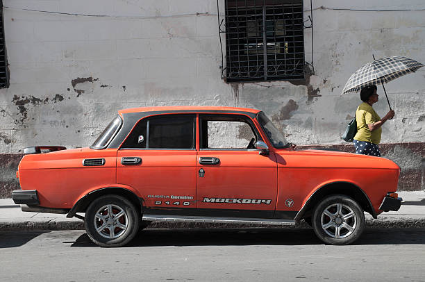 Cienfuegos, Cuba - August 19, 2015: Woman walk near Russian car named Moskvich.