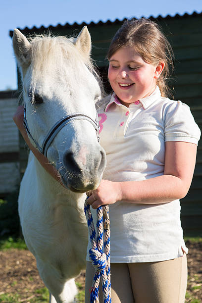 istock Girl Looking After Pet Pony 491616198