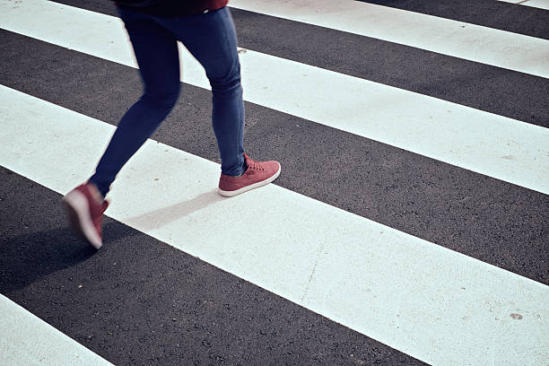 Zebra crossing Young woman crossing a zebra crossing. zebra crossing photos stock pictures, royalty-free photos & images