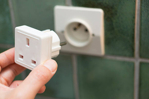 istock Close Up Of Hand Putting Travel Adapter Into Socket 491616630