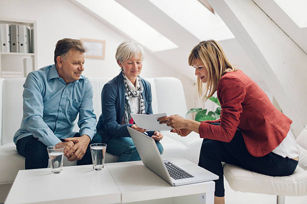 Mature Couple Meeting with Financial Advisor. Mature Couple Meeting with Financial Advisor. They are listening to financial advisor. She is speaking about retirement and insurance options for them. Holding contract in her hands and explaining to clients. cpa offers stock pictures, royalty-free photos & images