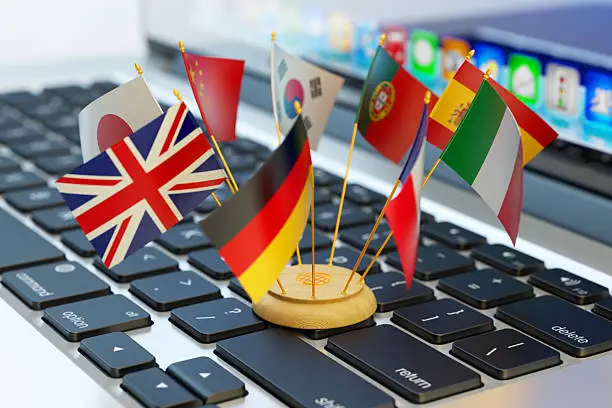 Translate and e-learning, national flags of the world countries on computer laptop keyboard